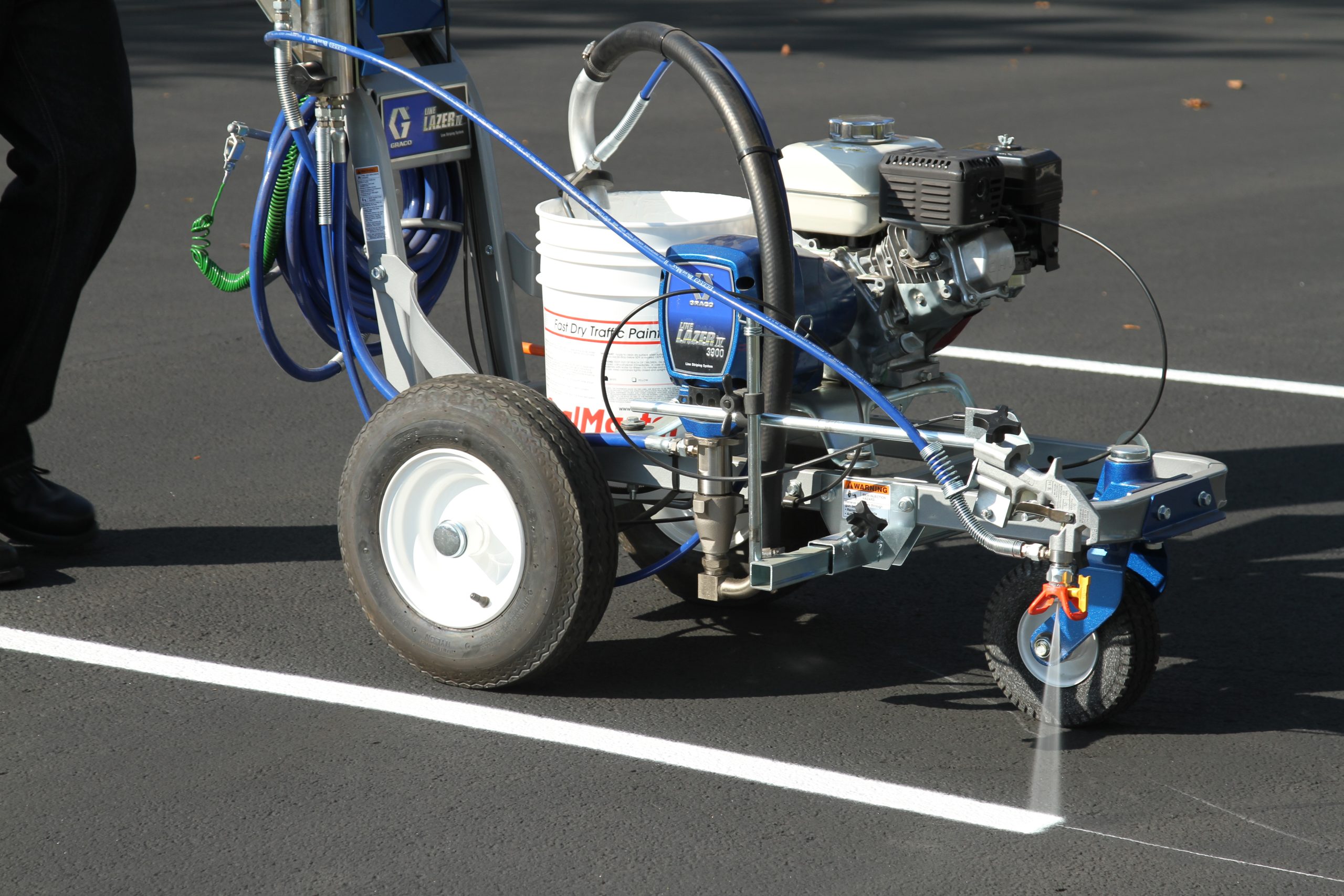 Local Sealcoating contractor applying SealMaster FlexMaster Crack Sealant (Cold-applied pourable crack sealant) into a crack an asphalt driveway or parking lot