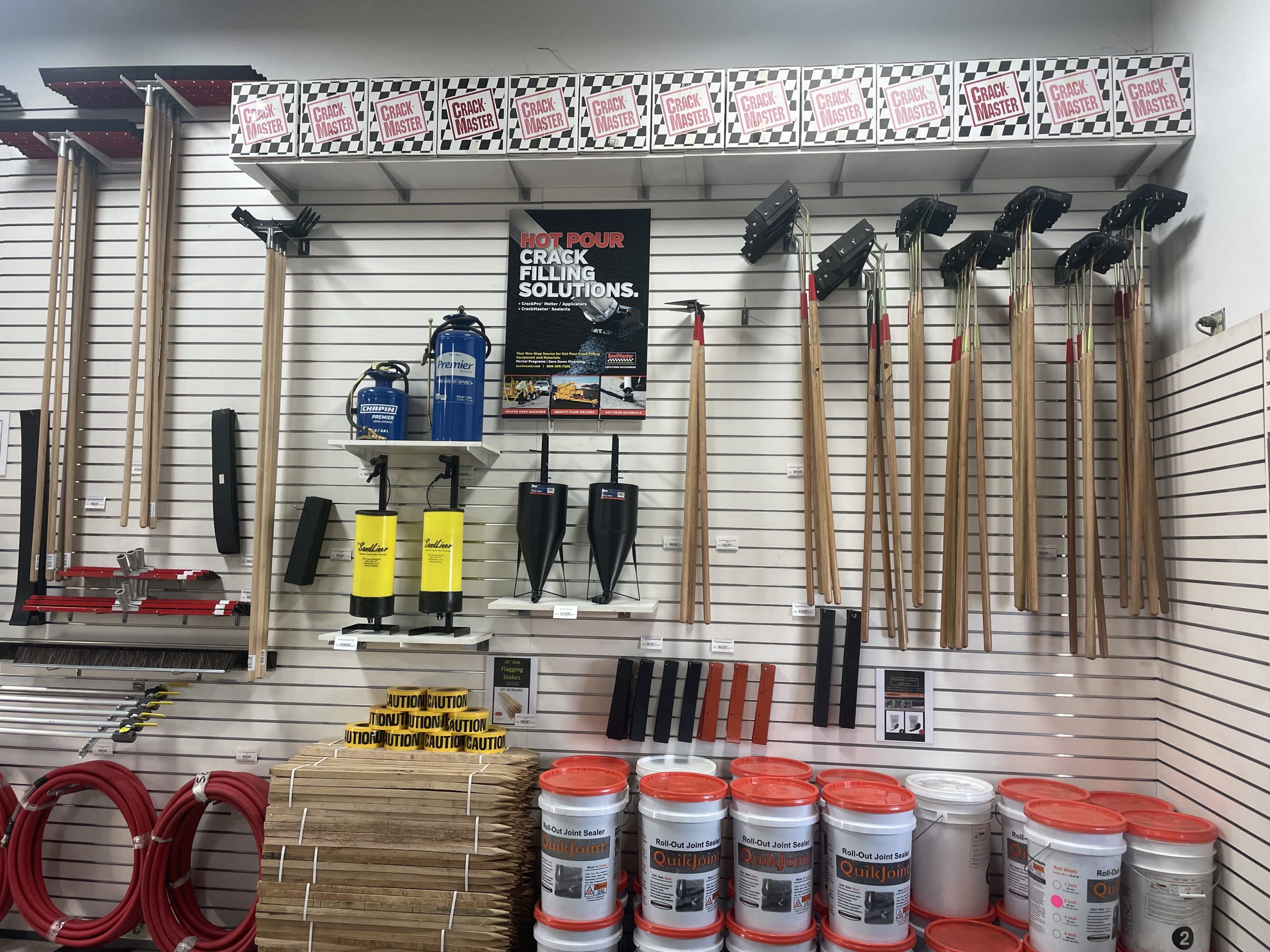 Fully stocked SealMaster storeroom with sealcoating equipment and products.