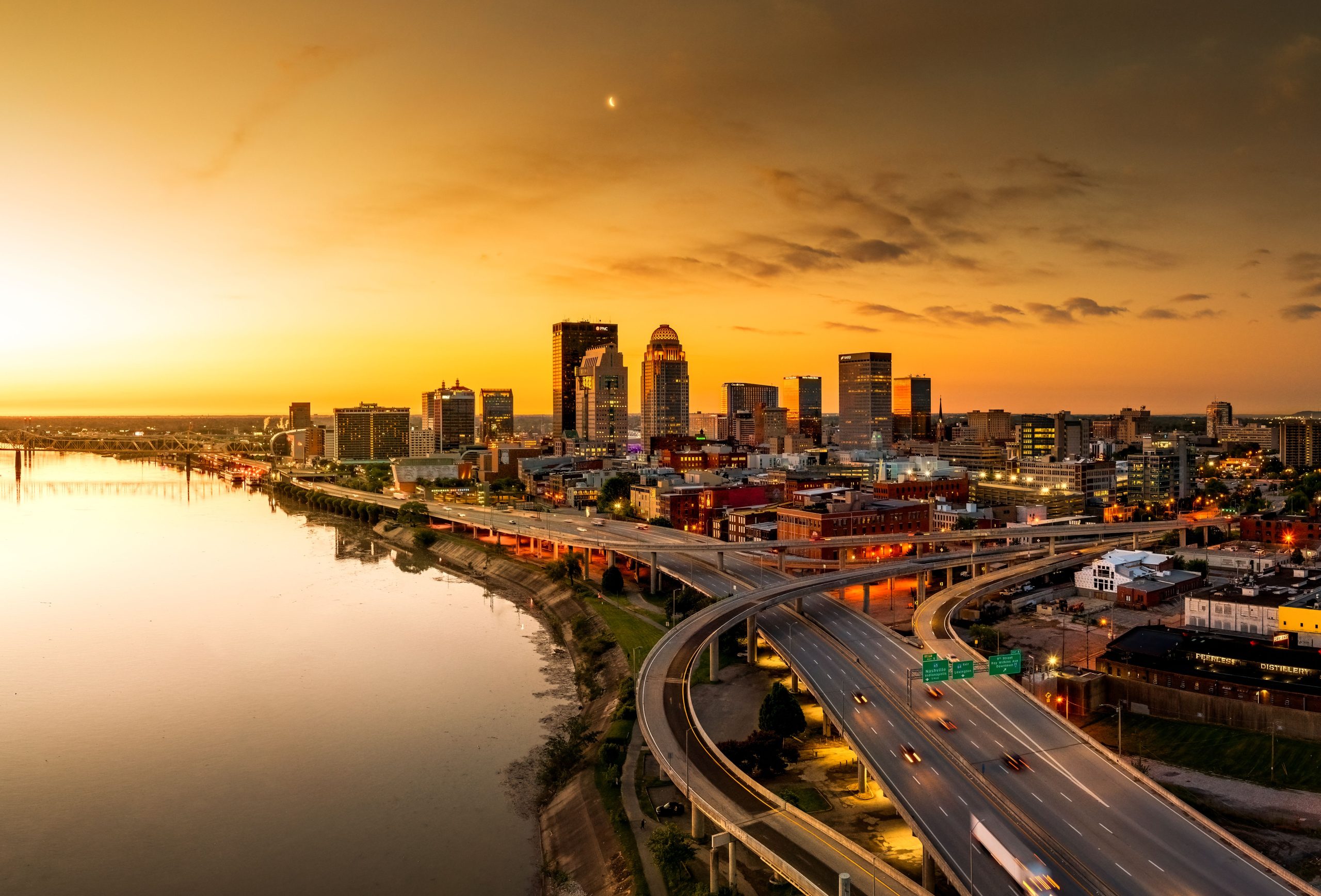 An aerial shot of the Louisville, KY bridge with the Ohio River at sunrise