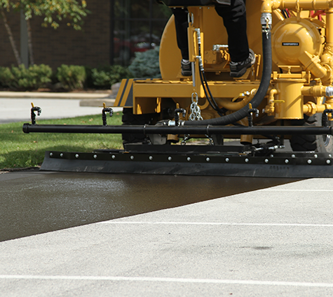 Local Sealcoating by SealMaster showing the process of sealing a parking lot.