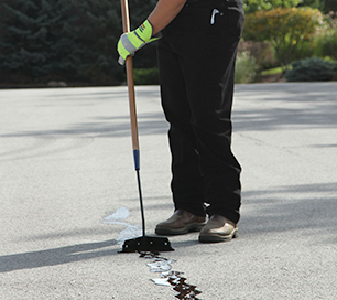 Crack filling being done by a sealcoating contractor using SealMaster products in Albuquerque, New Mexico.