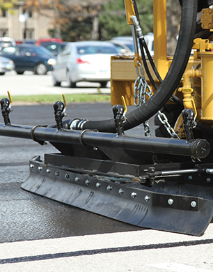 Asphalt sealcoating machine applied asphalt pavement sealer onto a parking lot.