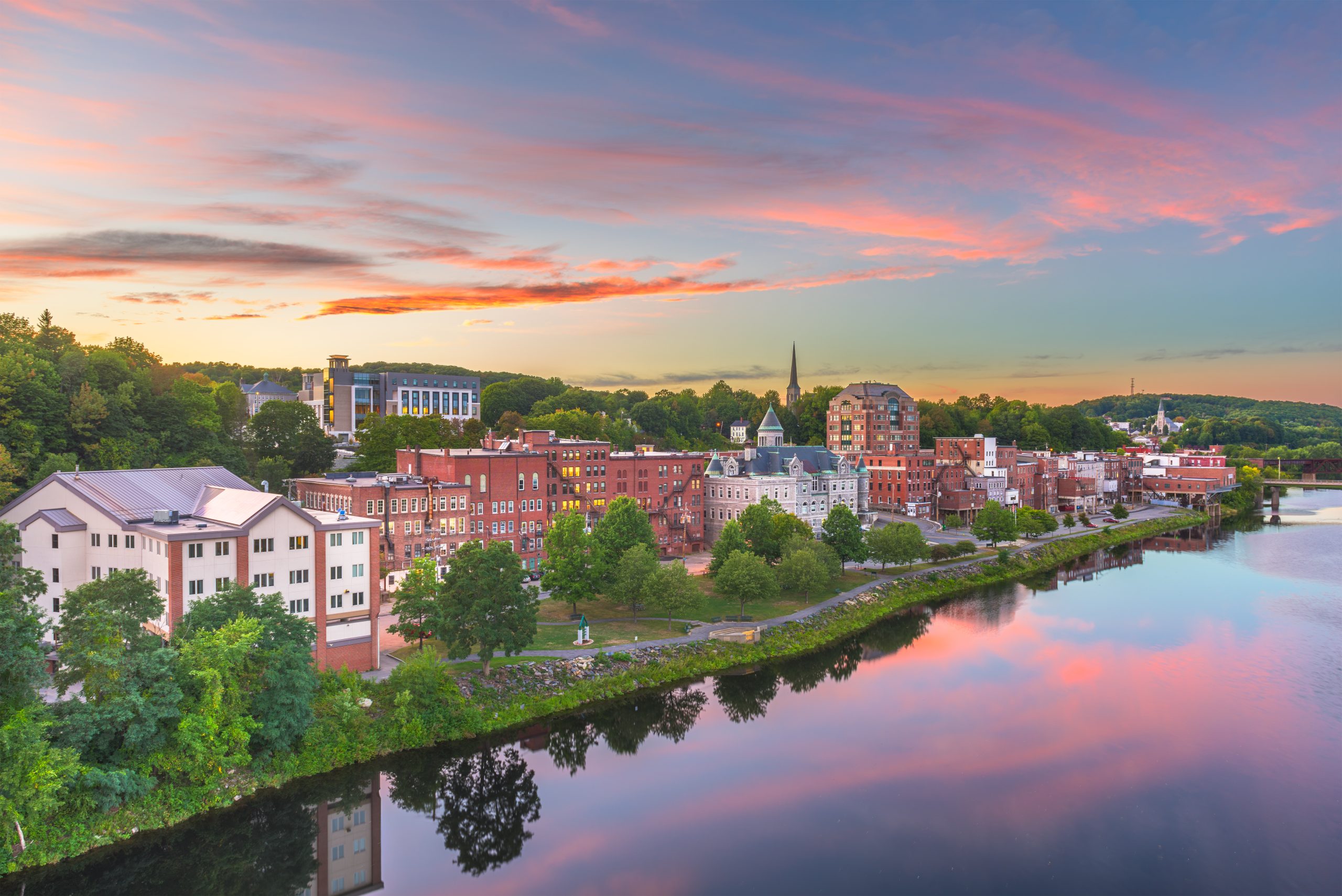 Augusta, Maine, USA town skyline on the Kennebec River at dusk.