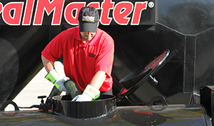 SealMaster FlexMaster Crack Sealant (Cold-applied pourable crack sealant) being applied to a crack in asphalt driveway by a local sealcoating contractor.