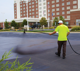 San Antonio Texas asphalt sealcoating contractors spray sealer on hotel parking lot