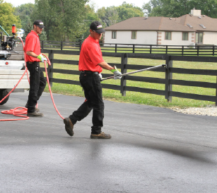 San Antonio Texas asphalt contractors apply sealer to a driveway