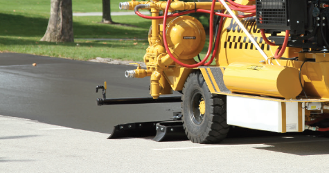 MasterSeal pavement sealer being applied by a local sealcoating contractor on a SealMaster squeegee machine